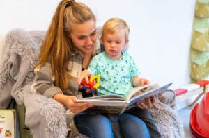 Familienhotel Gut Landegge im Emsland: Frau liest Kind aus einem Buch vor.