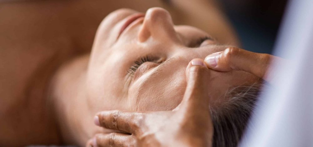 Familienhotel Gut Landegge im Emsland: Kosmetikbehandlung Wellnessmassage bei einer Frau am Kopf